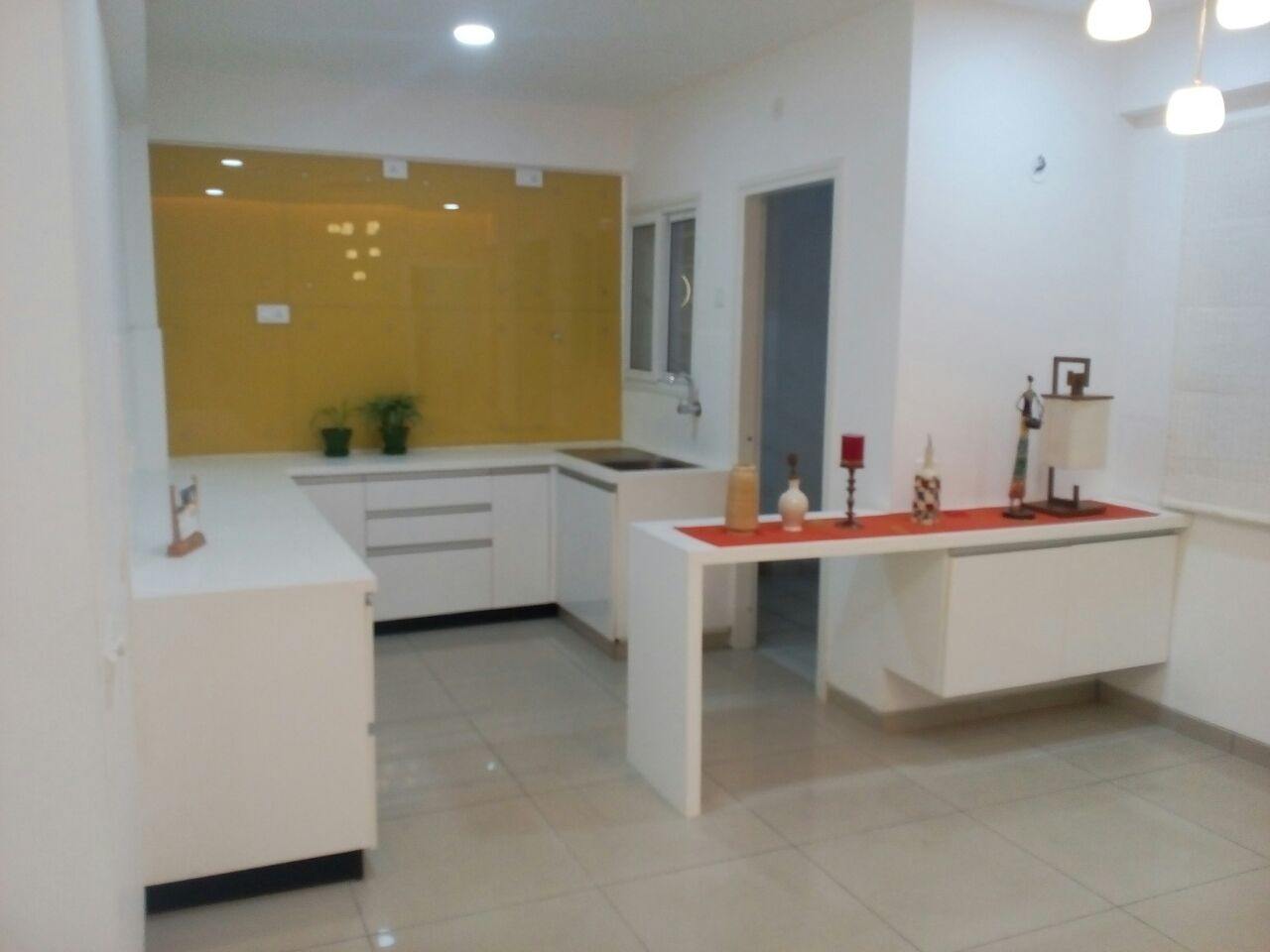 Glossy white Acrylic modular kitchen with yellow glass wall cladding